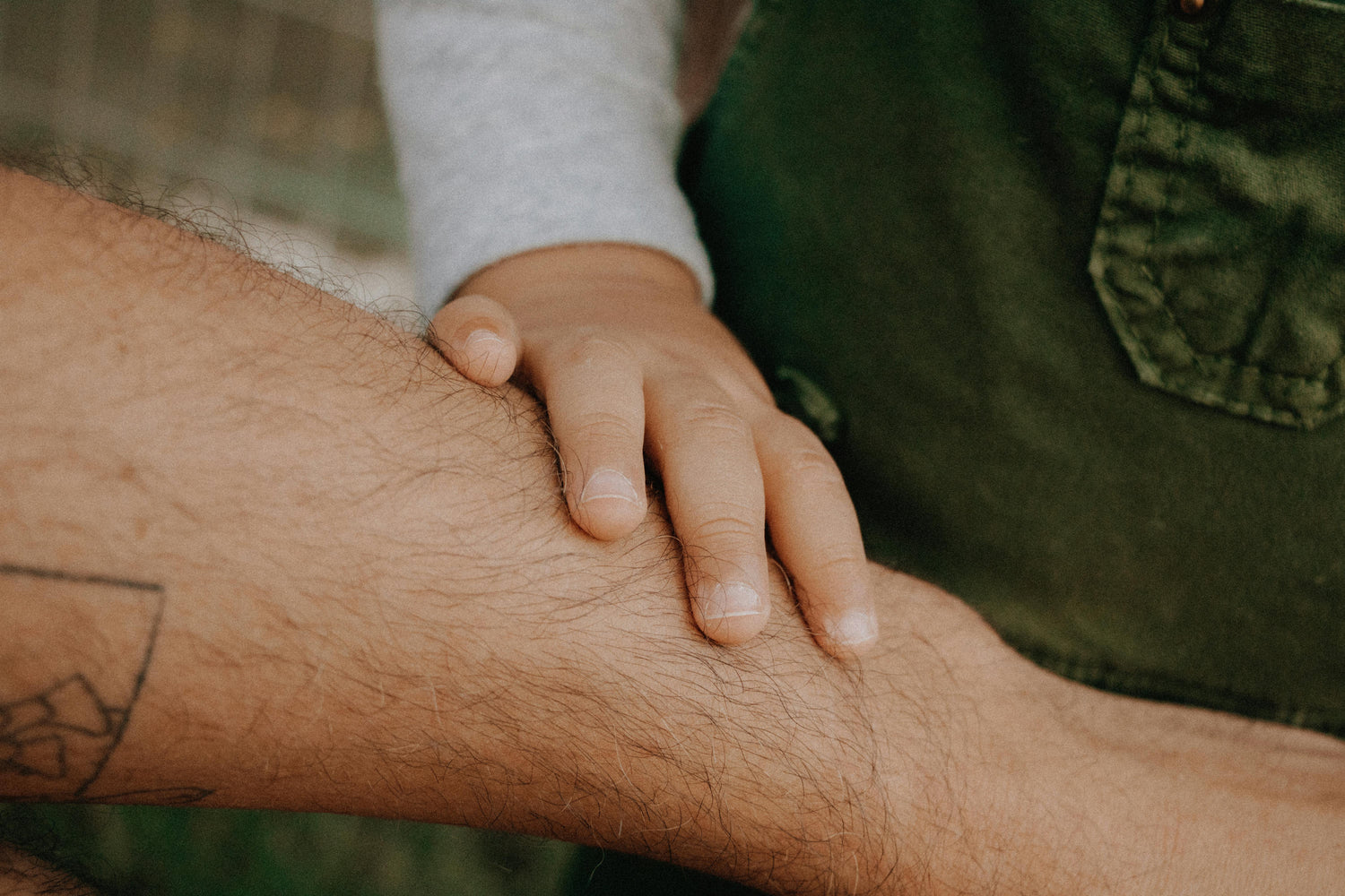 Kinderhand auf Papa Arm